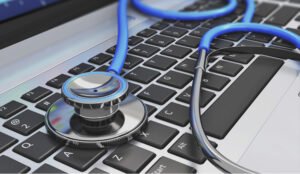 Stéthoscope bleu sur clavier d'ordinateur portable pour symboliser tech et santé.