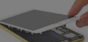 Démontage d'un appareil électronique, écran retiré, composants internes visibles.