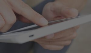 Doigts touchant l'écran tactile d'une tablette, illustrant un geste numérique.