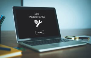 Ordinateur portable avec écran noir indiquant la maintenance d'une application et bouton entrer